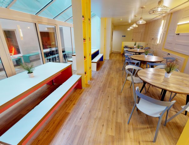 Dining room with wooden floor and large tables with bench seating at Fountain Halls - Portsmouth Student Accommodations university halls